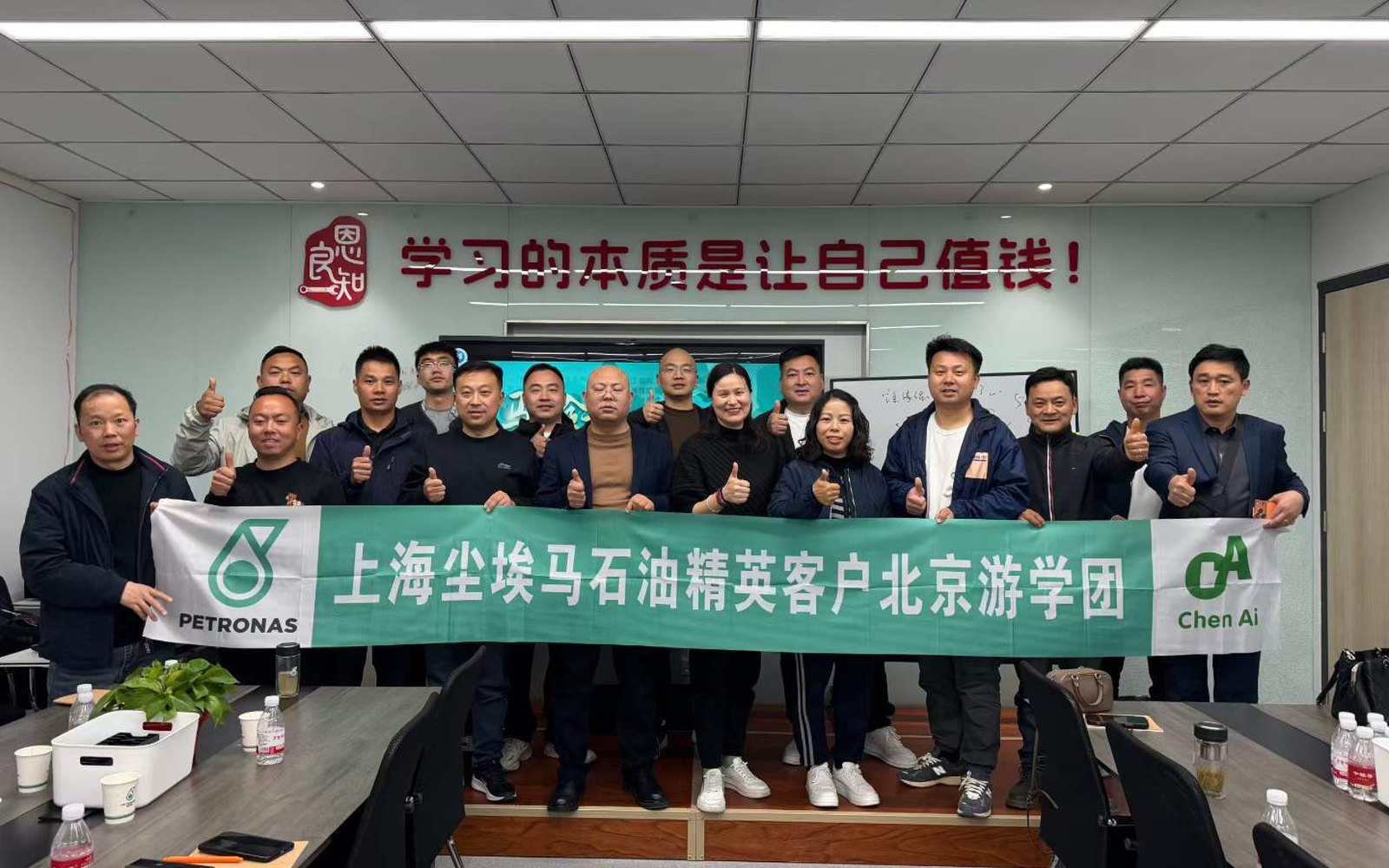 上海尘埃马石油精英客户北京游学团合影，横幅带有 PETRONAS 与上海尘埃贸易标识